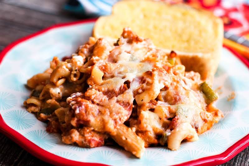 A Serving Of Mamma Ang's Cavatini On A Plate With Garlic Bread.