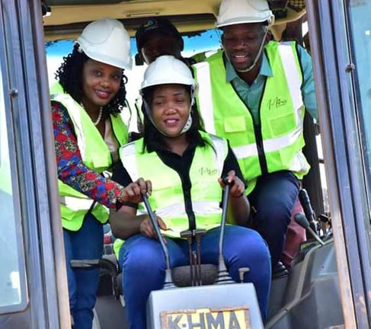 Safaricom Investment Co-operative CEO Sarah Wahogo riding an earthmover during the groundbreaking exercise at Ruaka in Kiambu county on Friday, September 23.