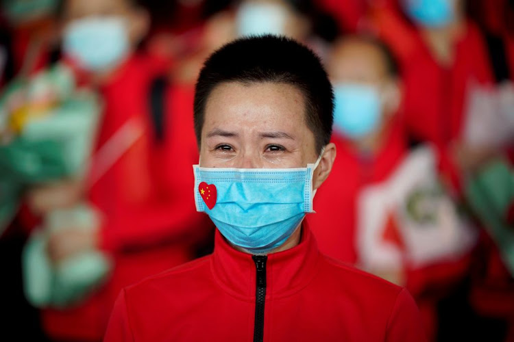 A member of a medical team weeps at the Wuhan Tianhe International Airport after travel restrictions to leave Wuhan, the capital of Hubei province and China's epicentre of the Covid-19 outbreak, were lifted, on April 8 2020.