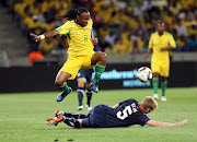 Siphiwe Tshabalala from Bafana Bafana jumps over Tim Ream from the USA during the Nelson Mandela Challenge between South Africa and USA at Cape Town Stadium on November 17, 2010 in Cape Town, South Africa. 