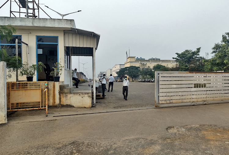 Private security guards stand at the entrance of a closed plant of Foxconn India, which makes iPhones for Apple Inc, near Chennai, India, December 22, 2021.