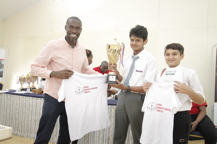 STEM impact centre partnership advisor Eric Nyamwaro with Ashwal Academy Junior Level winners Vrajesh Prakash and Maadhav Dodia.