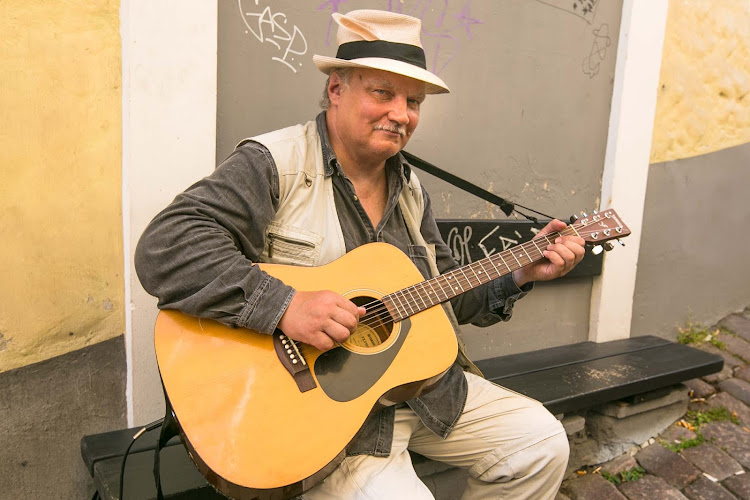 A street musician pauses for a visitor in Old Tallinn. 