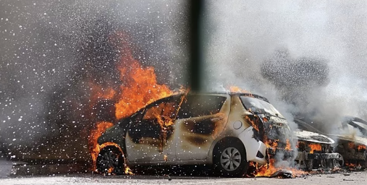 Cars are seen on fire following a rocket attack from the Gaza Strip in Ashkelon, southern Israel