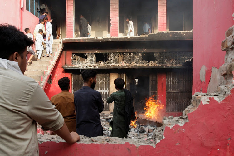 People gather at a church building vandalised by protesters in Jaranwala, Pakistan, August 16 2023. Picture: REUTERS/FAYYAZ HUSSAIN