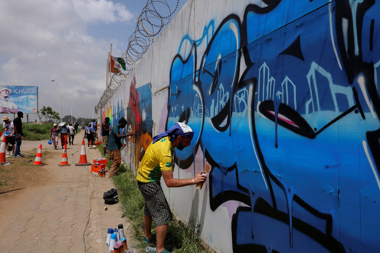 Street artists, who came to participate in the first edition of Graff Ivoire, paint graffitis and murals in a street in Abidjan, Ivory Coast on November 11, 2024.