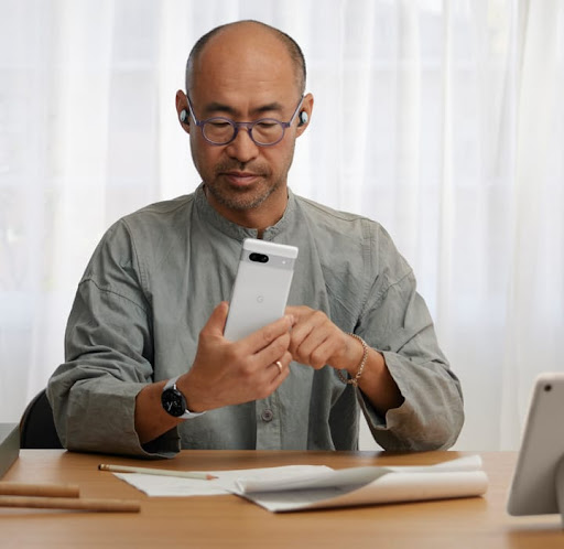 A man using a Google Pixel phone in his office.