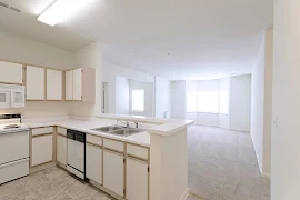 Kitchen with eat-in counter overlooks dining space ahead with bay window