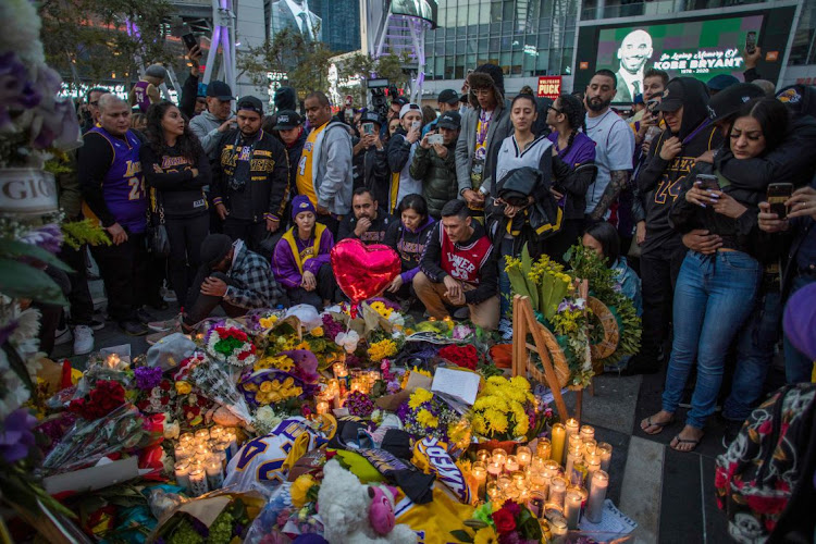 UTTER DISBELIEF: People gather around a makeshift memorial for former NBA and Los Angeles Lakers player Kobe Bryant after learning of his death in Los Angeles, US, on Sunday