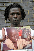 Actor, musician and AU ambassador for peace Emmanuel Jal holding a picture of himself when he was a child soldier in Sudan.