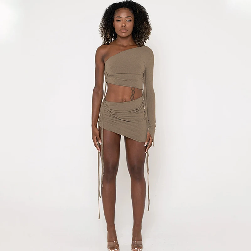 Traje de falda con cordón lateral superior que deja ver el abdomen de un hombro