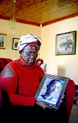 Mother Lumka M'belle  with a picture of her late son Thabang M'belle. / Tiro Ramatlhatse