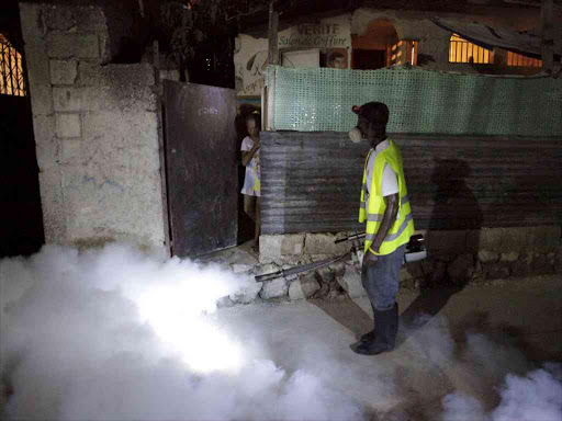 A girl looks at a worker of the Ministry of Public Health and Population as he fumigates against mosquito breeding, as well as to protect against Zika, during a regular fumigation campaign carried out together with FOKAL organisation in Martissant, Port-au-Prince, Haiti, February 2, 2016. Photo/REUTERS