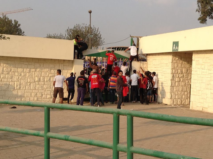 Al Ahly fans are senn climbing over walls to enter the match venue for the 2013 Caf Champions League second leg final against Orlando Pirates.