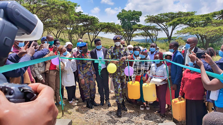 KDF Chief of Infrastructure Brigadier Dennis Kamuri cuts the ribbon during the commissioning of the Kaimbaga health centre borehole on Tuesday, August 25, 2020