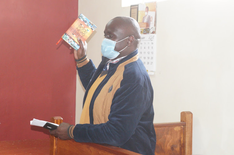 Corporal Collins Otieno from DCI Lari taking an oath at Limuru law court yesterday.