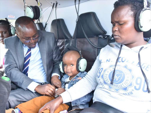 Ian Kipkoech being flown to Nairobi on Tuesday. On his right is Bomet Governor Joyce Laboso together with DP's aide Emmanuel Talam who accompanied him. /Felix Kipkemoi