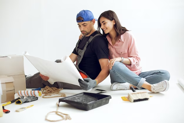 A guy and a girl look at their plan for building a studio