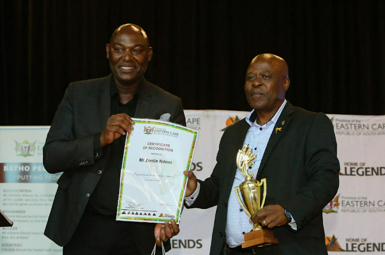 Eastern Cape safety and liaison department head Zukile Kani, left, hands the trophy to Zonile Ndoni