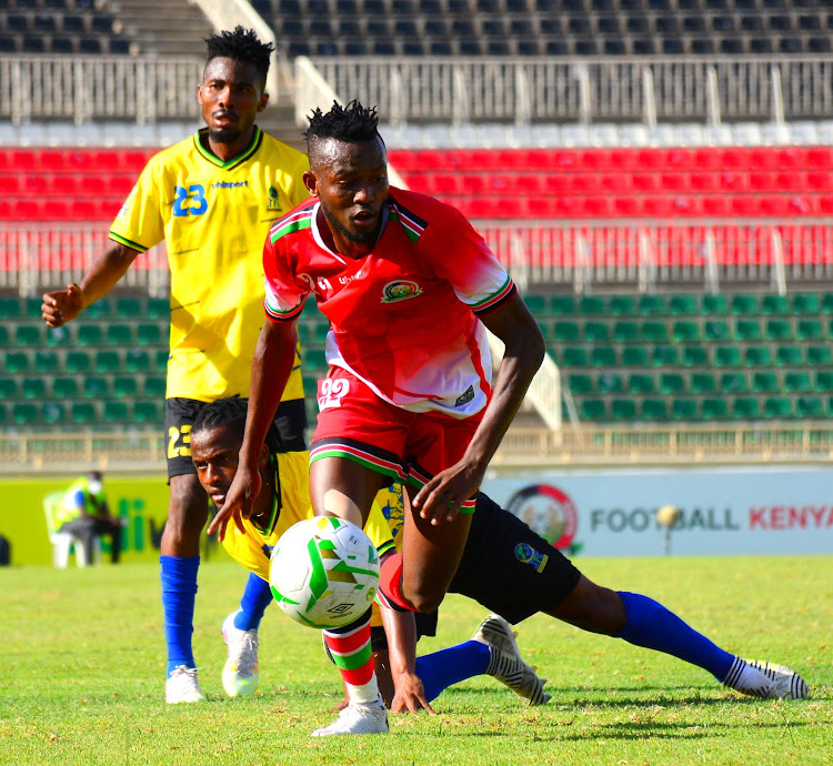 Harambee Stars' Hassan Abdalla (L) outpaces Mustapha Yassi and Suleimani Iddi of Tanzania during a friendly match at Nyayo Stadium