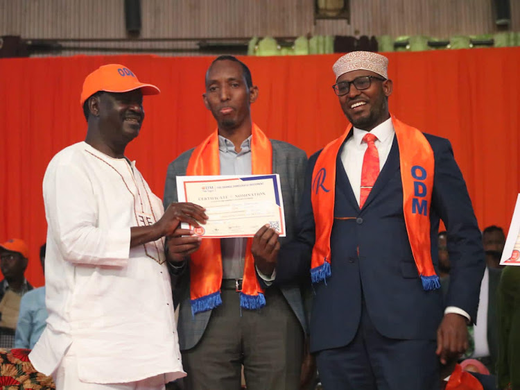 ODM leader Raila Odinga issues a certificate to Ahmed Muhumed and Wajir gubernatorial aspirant Ahmed Abdullah in Nairobi on Wednesday, April 20.