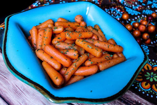 A bowl of Honey Glazed Carrots with parsley on top.