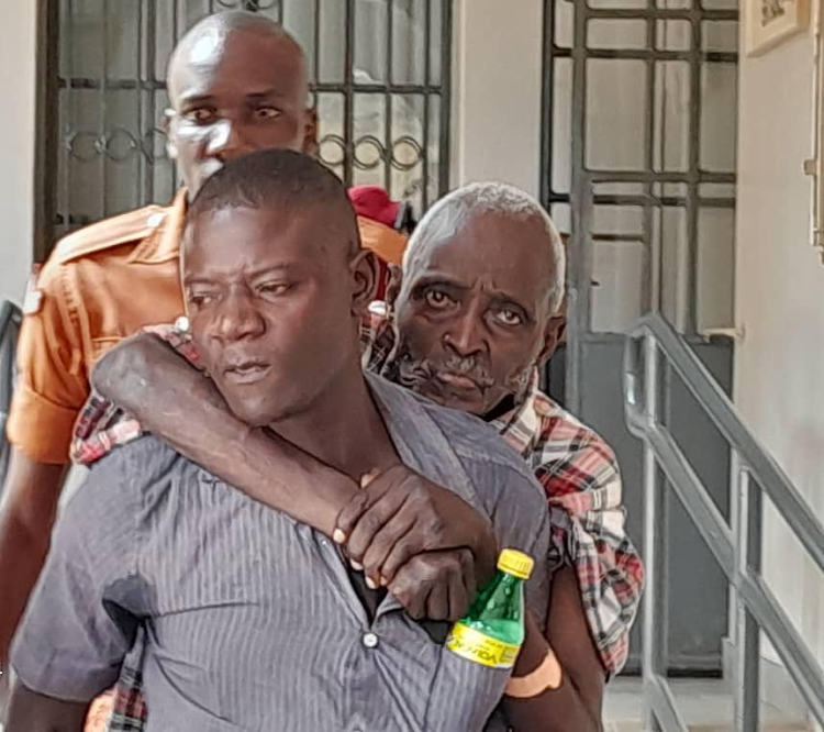 The Mzee being carried to the court room by an inmate