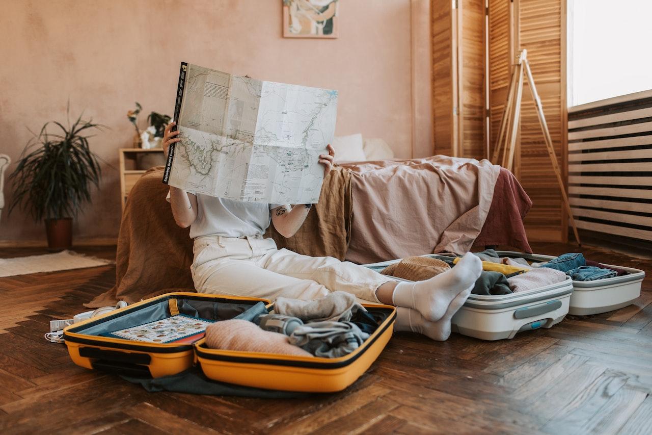 A person sitting on the floor with a map in front of her face

Description automatically generated