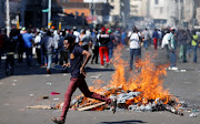 A man runs as supporters of the opposition Movement for Democratic Change party (MDC) of Nelson Chamisa burn barricades in Harare, Zimbabwe, August 1, 2018. 