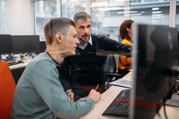 two males behind computer screen