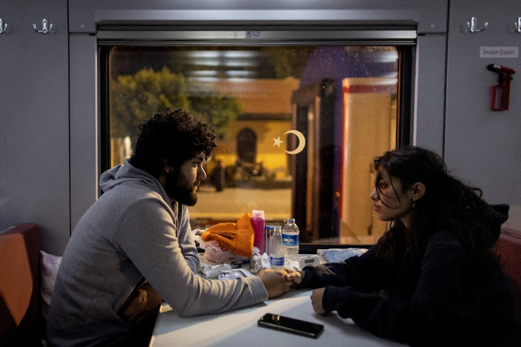 Yusuf Kurma and Aysel Ozcelik sit holding hands in one of the carriages at Iskenderun train station, as they talk about their upcoming marriage, in Iskenderun, Turkey, on February 18 2023. Picture: REUTERS/ELOISA LOPEZ