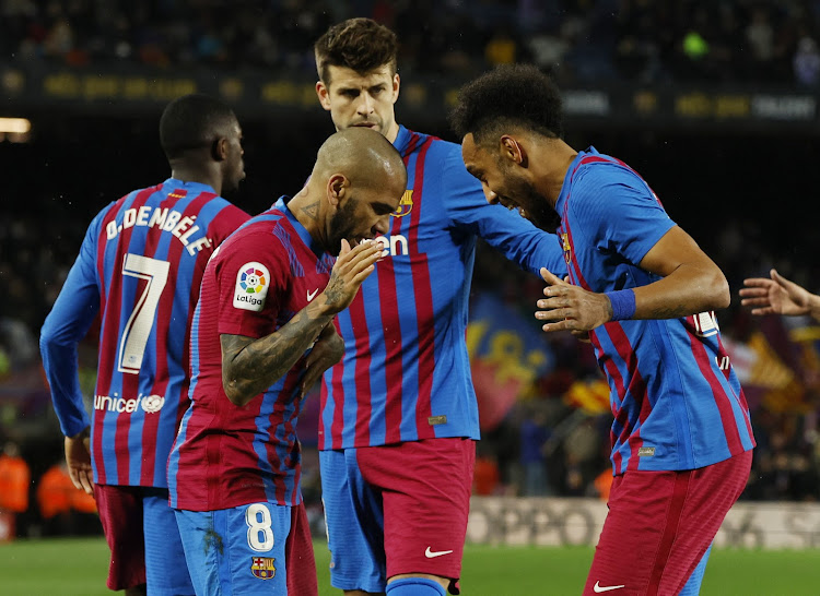 Barcelona's Pierre-Emerick Aubameyang (R) celebrates with Dani Alves and Gerard Pique after scoring against Osasuna in a recent La Liga match