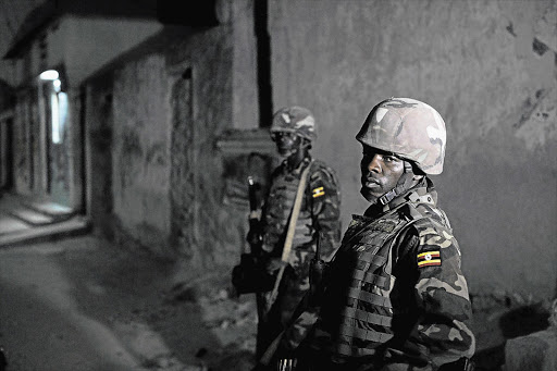 Soldiers belonging to the AU Mission in Somalia stand guard during an operation in the Wardhiigley district of Mogadishu, in an attempt to weed out members of the Al-Shabab extremist group