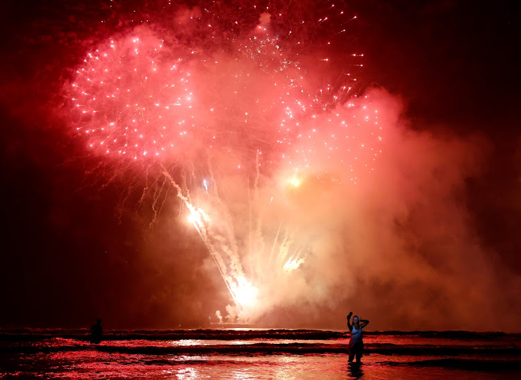 SANTOS, BRAZIL - JANUARY 01: A person takes a selfie as Brazilians celebrate during fireworks marking the start of the New Year at Gonzaga beach on January 1, 2023 in Santos, Brazil.