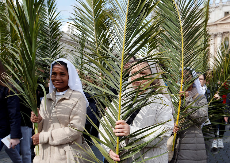 Nuns hold palm branches at the start of the Palm Sunday Mass led by Pope Francis at Saint Peter's Square at the Vatican./REUTERS