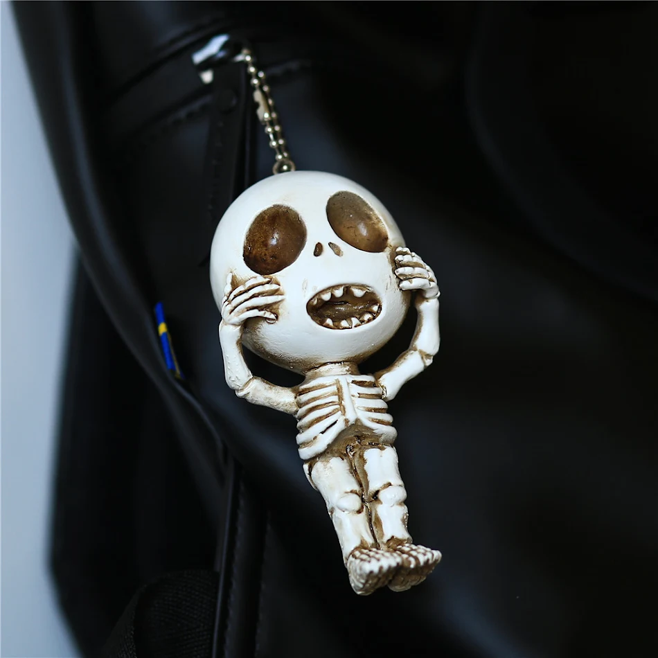 Porte-clés pendentif crâne mignon et original avec un visage amusant, petit, en résine. Idée cadeau quirky et pleine d'humour.