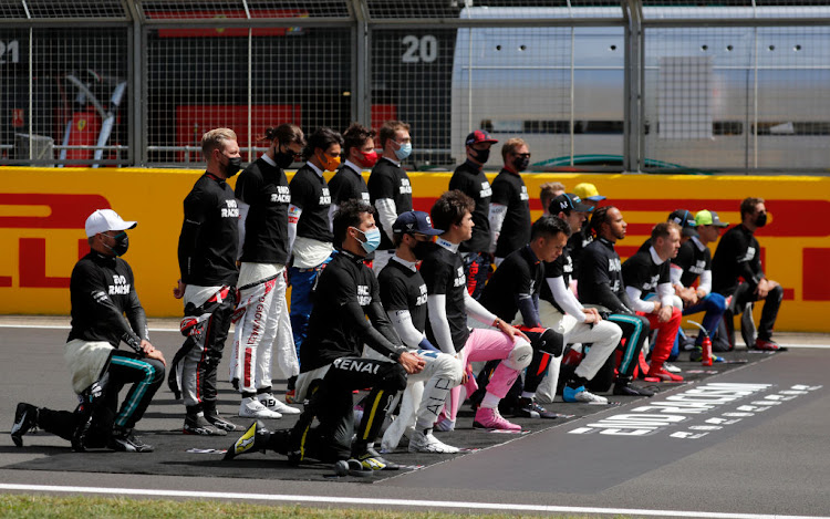 Drivers take a knee against racism in the pit lane before the start of the 2020 British Grand Prix at Silverstone, Northamptonshire.