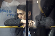 A family member of a passenger onboard Malaysia Airlines Flight MH370 waits on a bus before heading to the Malaysian embassy, outside Lido Hotel in Beijing. REUTERS