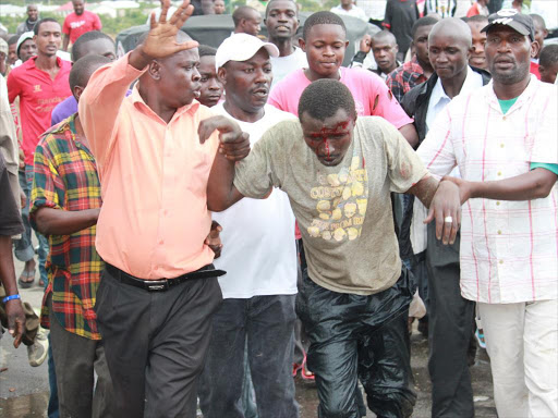 A mob justice victim being rescued by human rights activists from an angry mob. PHOTO/FILE