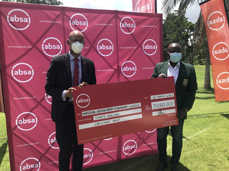 Kenya Open Golf Limited (KOGL) tournament director Patrick Obath (R) receives a cheque from Absa Bank managing director Jeremy Awori towards Magical Kenya Open and the Kenya Savannah Classic