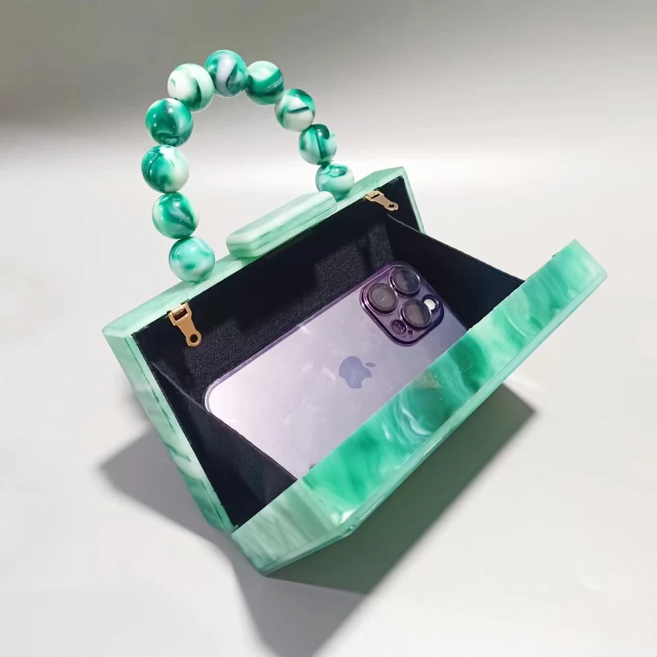 Pochette de soirée femme en acrylique nacré, accessoire élégant. Parfait pour les événements spéciaux, ajoute une touche de glamour à votre tenue.