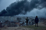 People watch as smoke rises after an airstrike, as Russia's attack on Ukraine continues, in Lviv, Ukraine on March 26 2022. 