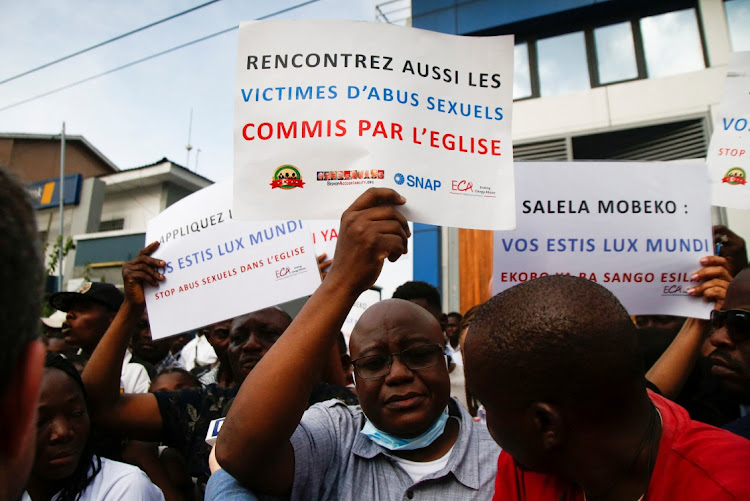 Benjamin Kitobo, a member of Ending Clergy Abuse (ECA) who said that he was sexually abused at the age of 18 by a priest in Kolwezi, holds a sign that reads "Meet the victims of sexual abuse committed by the church also" as he protests in front of the Catedral Notre Dame De Lingwala, where Pope Francis came to meet Roman Catholic bishops in Kinshasa, Democratic Republic of Congo February 2, 2023.