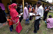 Villagers wait outside a National Register of Citizens (NRC) centre to get their documents verified by government officials in the northeastern state of Assam, India in July 2018.