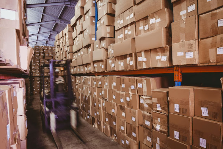 A worker operates a forklift in a row of shelves with boxes in a large warehouse Picture: 123RF/WAVEBREAK MEDIA LTD