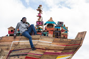 Vrygrond resident Keemo Mowers on top of the sculpture built in the township.