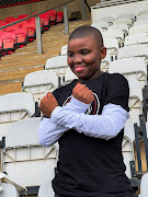 Happy Tswangae makes Pirates' skull and crossbones sign in the stands at Rand Stadium.
