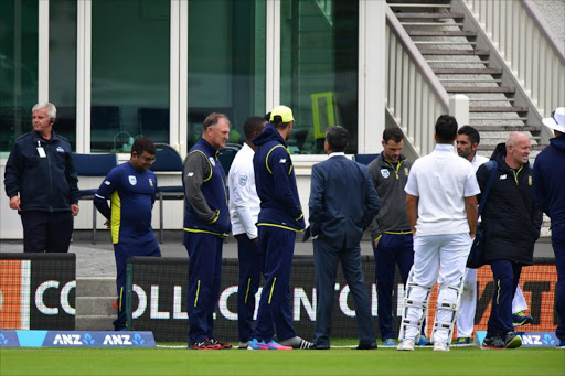 South African players and officials evacuate after a fire alarm sounded in the main stand during day three of the first international cricket test match between New Zealand and South Africa at the University Oval in Dunedin on March 10, 2017.