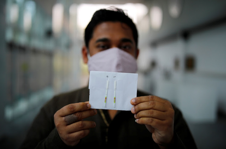 Debojyoti Chakraborty, Senior Scientist, at the Council of Scientific and Industrial Research (CSIR) Institute of Genomics and Integrative Biology, shows the coronavirus disease (Covid-19) tests results done by 'Feluda' paper strips based test developed by CSIR, in New Delhi, India, November 11, 2020.