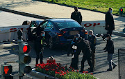 Law enforcement officers hold up a U.S. Capitol Police jacket at the site after a car rammed a police barricade outside the U.S. Capitol building on Capitol Hill in Washington on April 2, 2021. 